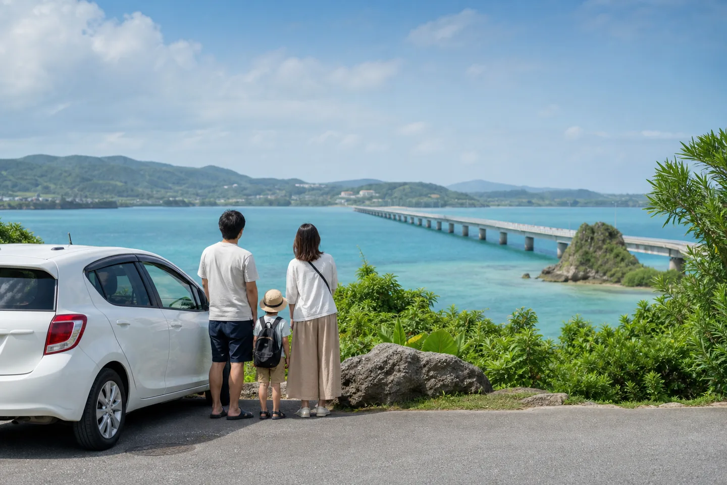 一家三口站在租車旁看著沖繩北部海景與跨海大橋